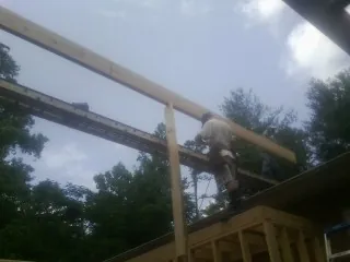 Carpenter setting a ridge beam over a new addition frame — Ice Dam Removal by Roofing Brothers in Sunderland