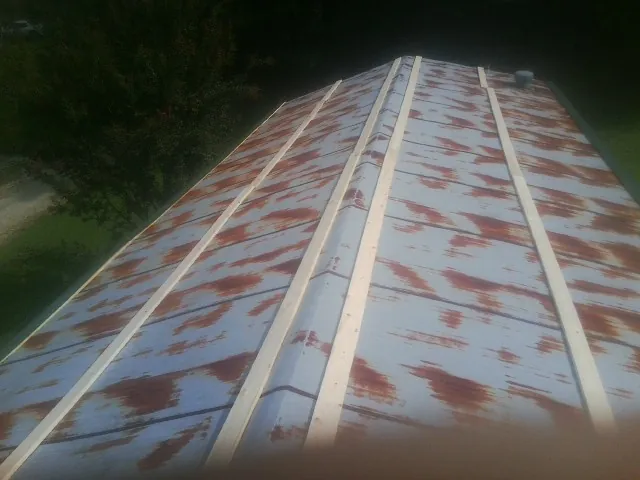 Rusted metal roof panels with new wood purlins before replacement — Storm Damage Roof Repair in Sunderland by Roofing Brothers