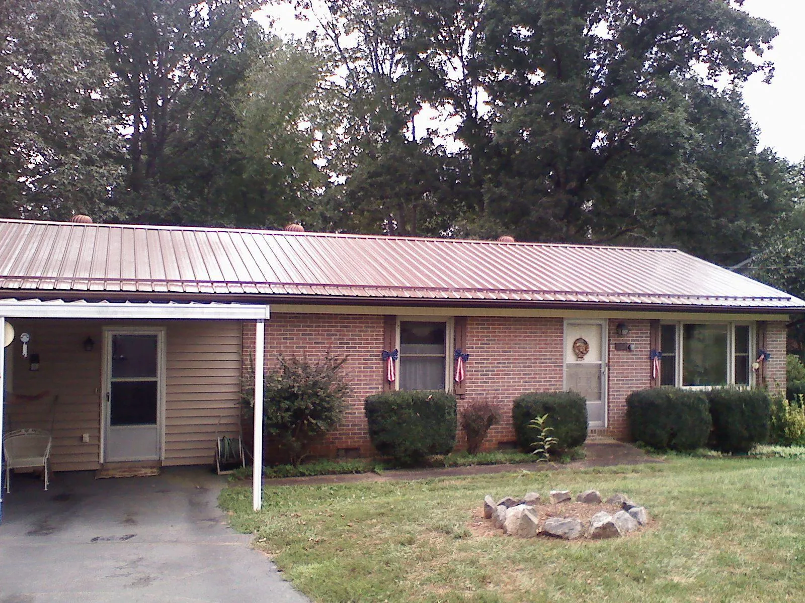 Bronze metal roof and carport on a brick ranch home — Roof Repair work by our crew in Sunderland